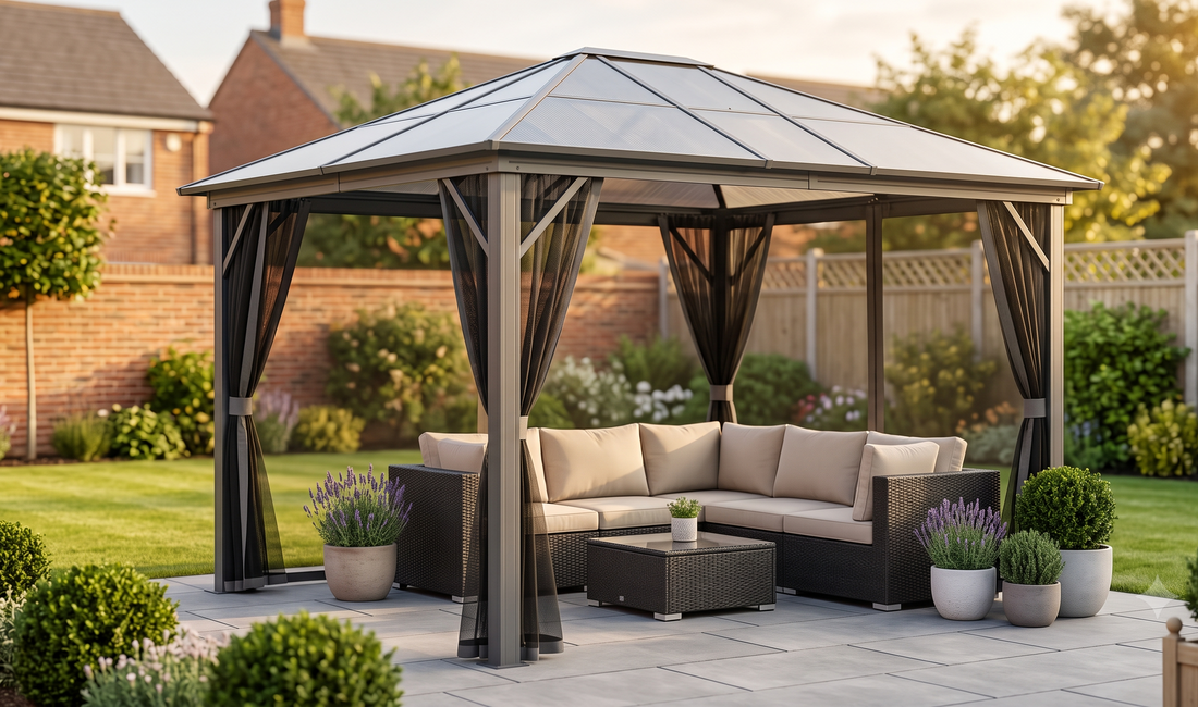 Modern grey hardtop gazebo with integrated curtains beside a charcoal rattan garden sofa on a paved UK backyard patio, soft s
