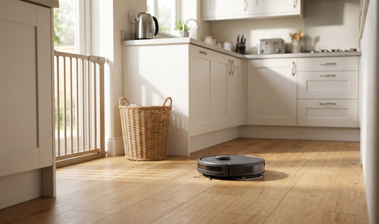 Modern UK semi-detached kitchen with light wood floor, ECOVACS robot vacuum and mop cleaning autonomously beside a tidy baby 